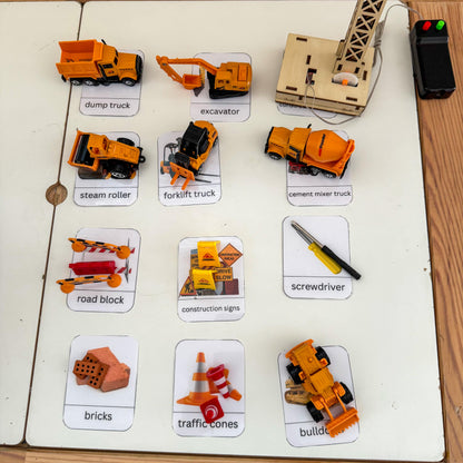 Construction-themed educational cards with toy models on a white surface